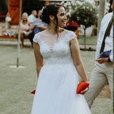 Bride holding red bean bag playing with cornhole set for on-site weddings in outdoor garden