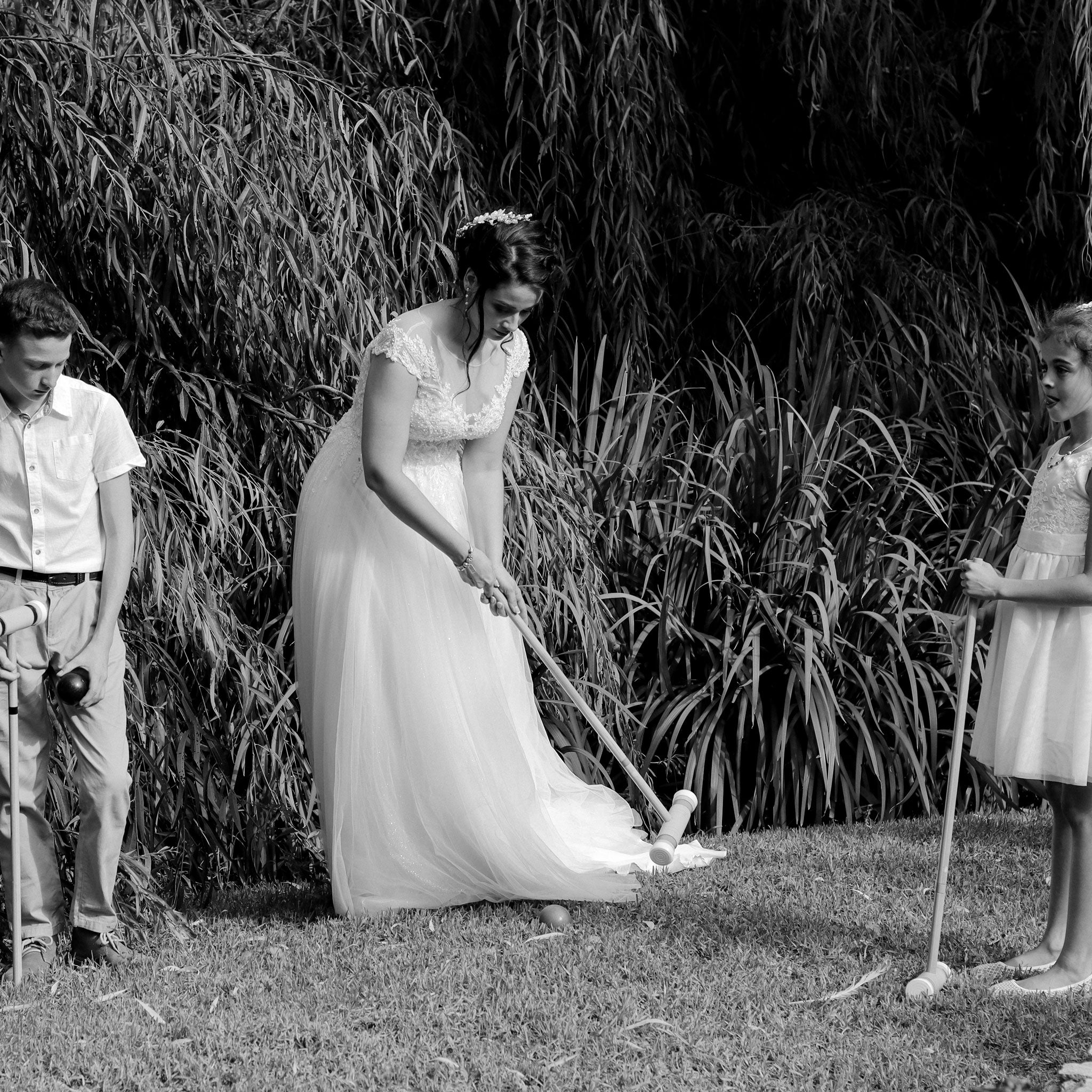 Bride and children playing croquet outdoors in a garden with croquet rental forevermore moments