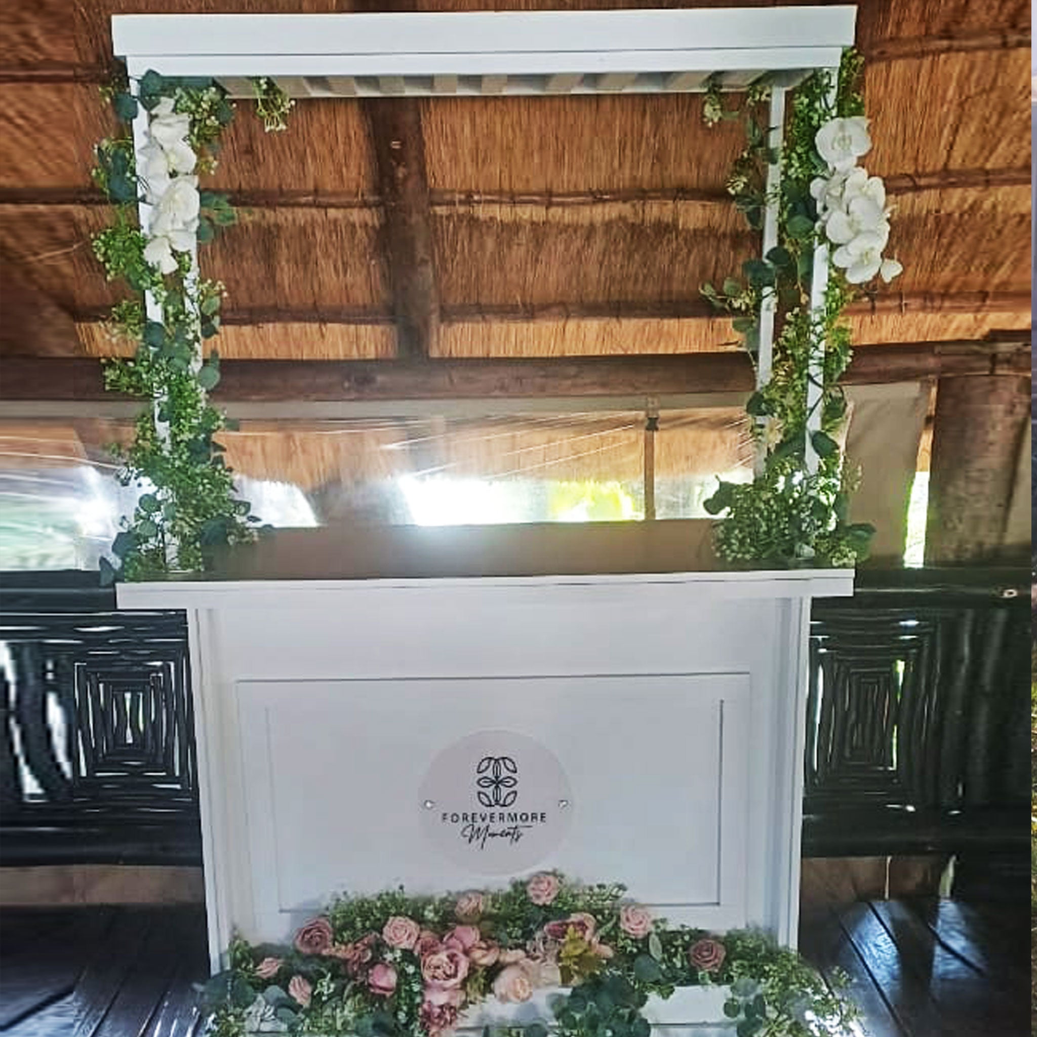 White on-site wedding reception cart by Forevermore Momentos decorated with flowers and greenery