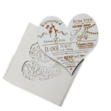Heart-shaped laser-cut wedding invitations with intricate floral design and RSVP details
