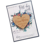 Laser-cut wooden heart magnet attached to floral save the date card with names Olivia and Anton