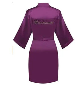 Personalized bridal party sleepwear in purple satin robe with embroidered bridesmaid text on the back