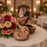 Personalized heart wood ring box open with an engagement ring inside, next to a floral bouquet