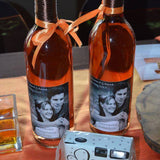 Wedding wine bottles with personalized wine labels wedding featuring a couple's photo and orange ribbon ties
