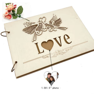 Rustic wood wedding guest book with a heart-shaped cutout and decorative bird design