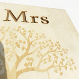 Rustic wood wedding guest book featuring an elegant tree design and engraved 'Mrs' text