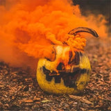 Halloween pumpkin filled with orange smoke from wedding party smoke bomb props for festive celebrations