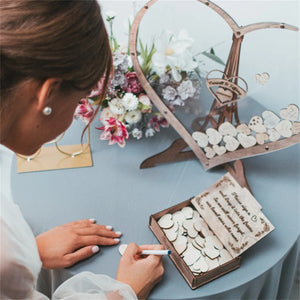 Wooden heart wedding guest book display with personalized messages and decorations for a romantic celebration