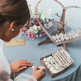 Wooden heart wedding guest book display with personalized messages and decorations for a romantic celebration