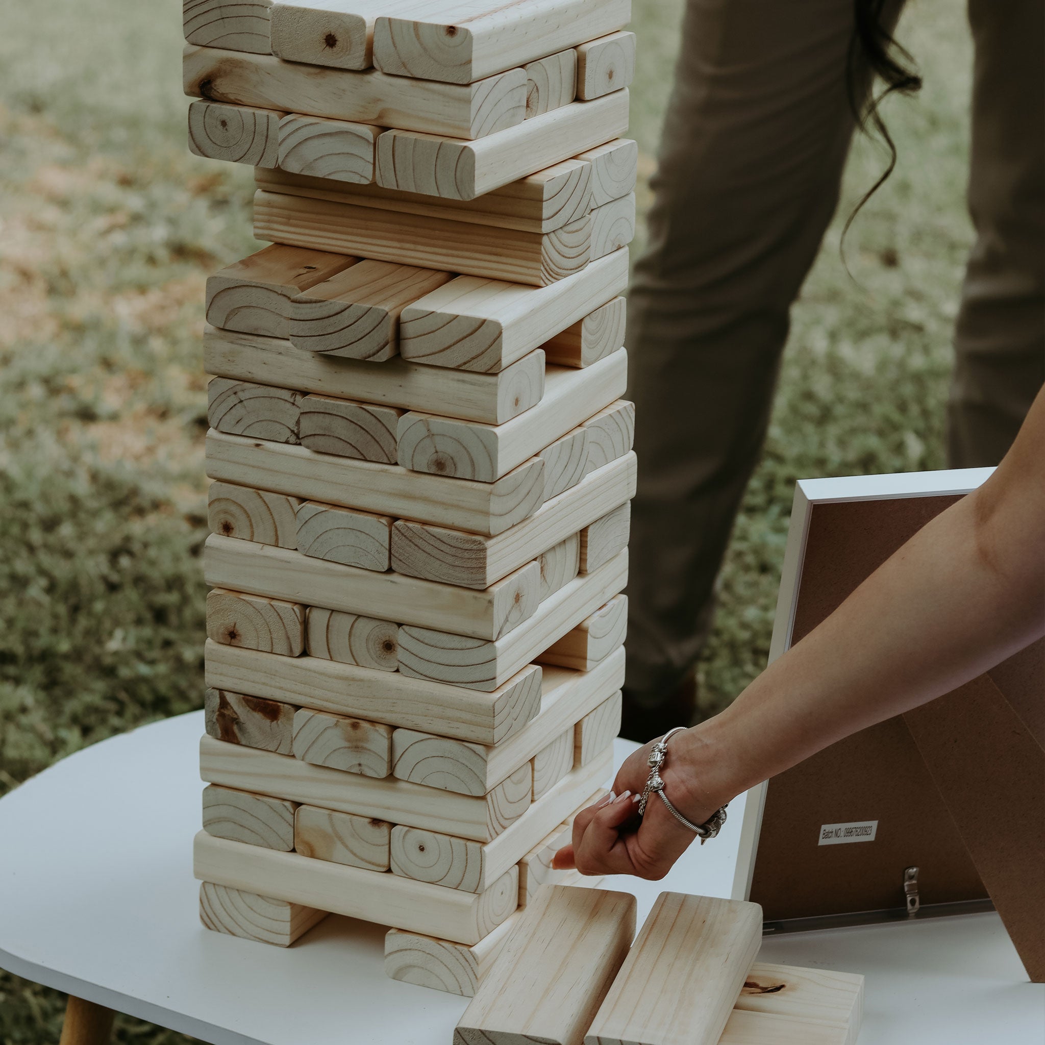 On-site Jenga game for weddings with large wooden blocks stacked on a white table